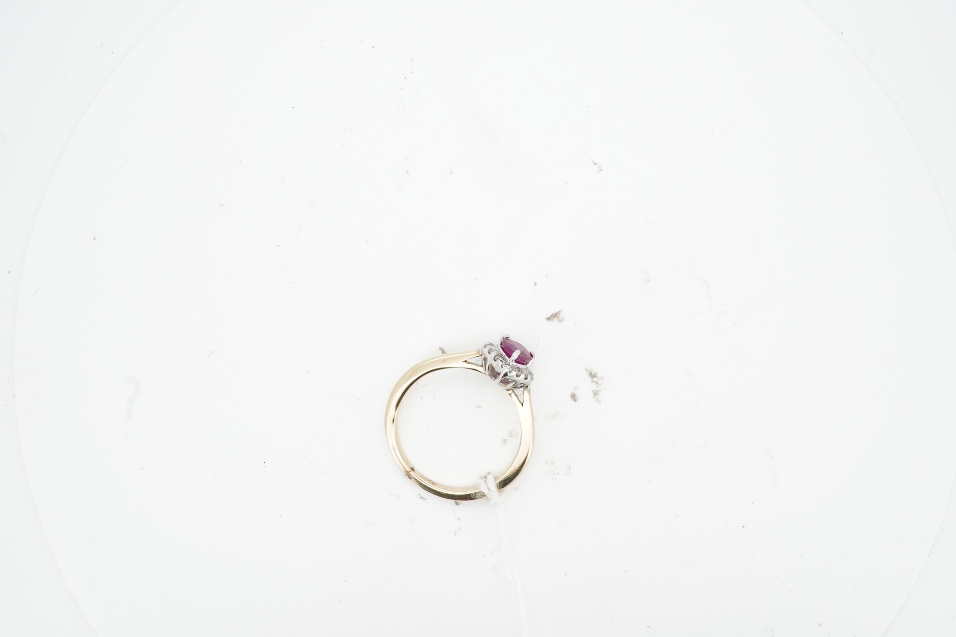 A ruby and diamond cluster ring, claw-set with a pear-shaped ruby weighing approximately 0.60 carats, within a border of brilliant-cut diamonds totalling approximately 0.42 carats, mounted in 14ct gold, size N, British h